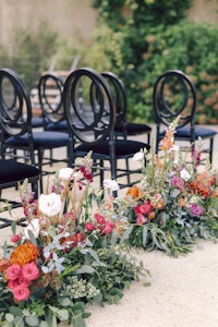 a row of chairs with flowers on the ground