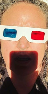 a woman with curly hair wearing 3d glasses