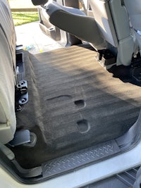 the back seat of a vehicle with a black floor mat