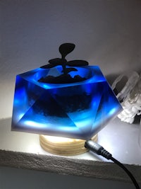 a blue led lamp with a plant on it