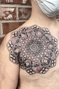 a man with a mandala tattoo on his chest