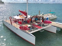 a group of people standing on the deck of a catamaran