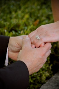 a man is holding a woman's wedding ring