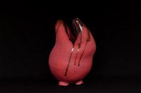 a red vase on a black background