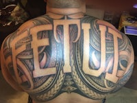 a man with a tattoo on his back that says fetu