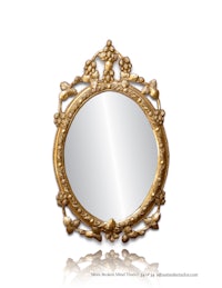 an ornate gold mirror on a white background