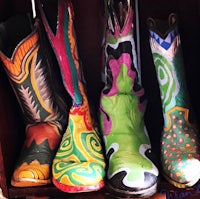 four colorful cowboy boots are lined up on a shelf