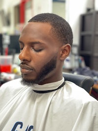 a man sitting in a barber chair with his eyes closed