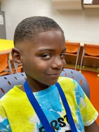 a young boy wearing a lanyard in a classroom