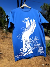 a blue t - shirt with a hand drawn on it