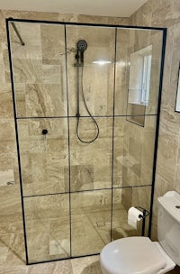 a bathroom with a glass shower enclosure and toilet