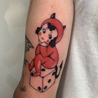 a tattoo of a devil wearing a red outfit