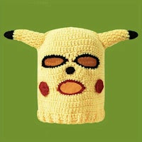 a crocheted pikachu mask on a green background