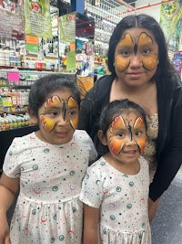 two girls with butterfly face paint in a grocery store
