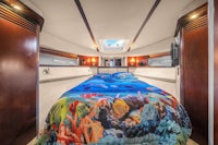 a bed in a boat with a colorful comforter
