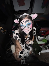 a girl in a cow costume sitting on the floor