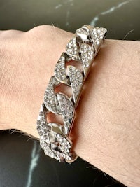 a person wearing a bracelet with diamonds on it