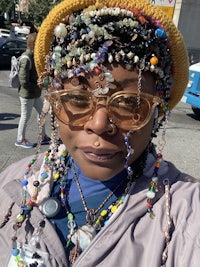 a woman wearing a beaded hat and glasses