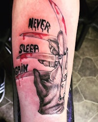 a tattoo with the words never sleep again and a hand with a knife
