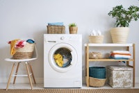 a laundry room with a washing machine and baskets