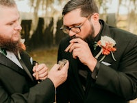 two grooms smoking a cigar at a wedding