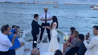 a wedding ceremony on a boat with a bride and groom