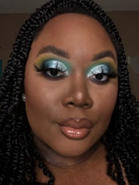 a black woman with blue and green eye makeup