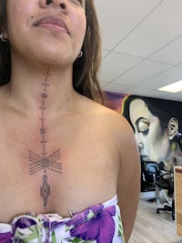 a woman with an arrow tattoo on her chest