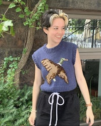 a woman wearing a sweater with a bird on it