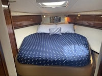 a bed in a boat with a blue comforter