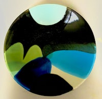 a glass plate with a blue, green, and black design