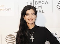 a woman in black standing on a red carpet