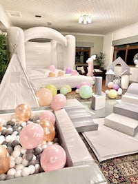 a room filled with balloons and a bounce house
