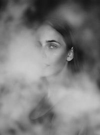 a black and white photo of a woman with smoke in her eyes