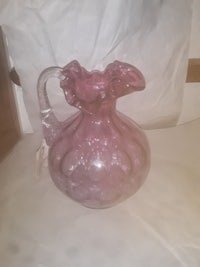 a pink glass pitcher sitting on a table