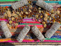a pile of beads and sage on a colorful rug