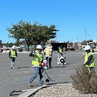 a group of construction workers with shovels in a parking lot