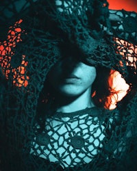 a woman in a black lace dress covering her face