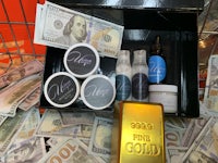 a gold bar and other items in a basket with money