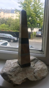 a stone obelisk sitting on top of a window sill