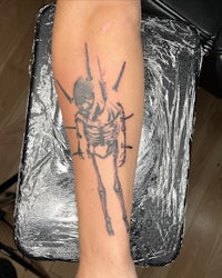 a tattoo of a skeleton on a person's forearm