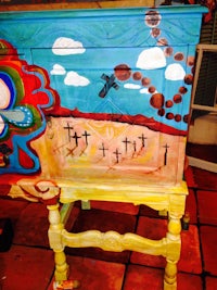 a painted dresser with a cross painted on it