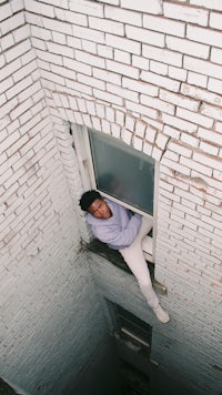 a man sitting in a window of a building