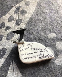 a ceramic bird with a poem on it