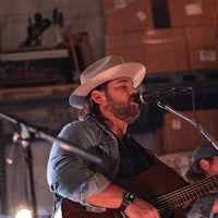 a man in a cowboy hat singing into a microphone