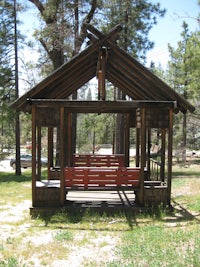 a wooden swing set with a red bench