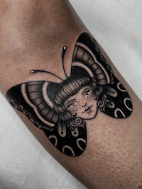 a black and white tattoo of a woman with a butterfly on her arm