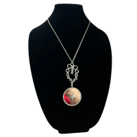 a silver necklace with a red pendant on it