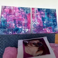 two paintings on a bed next to a pillow