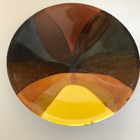 a plate with a yellow, brown and black design